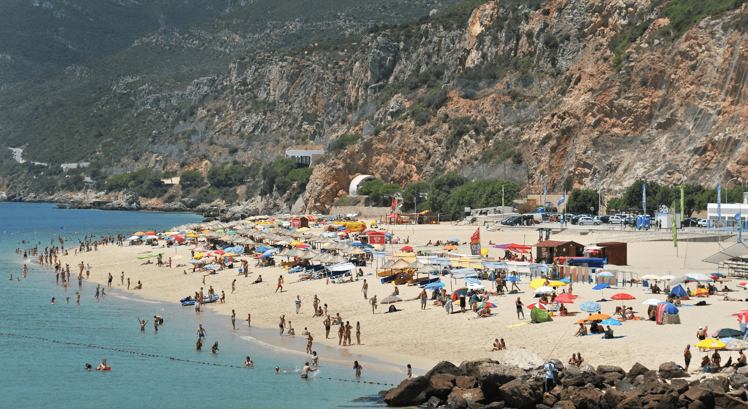 Busy Figueirinha beach beneath the Serra da Arrábida