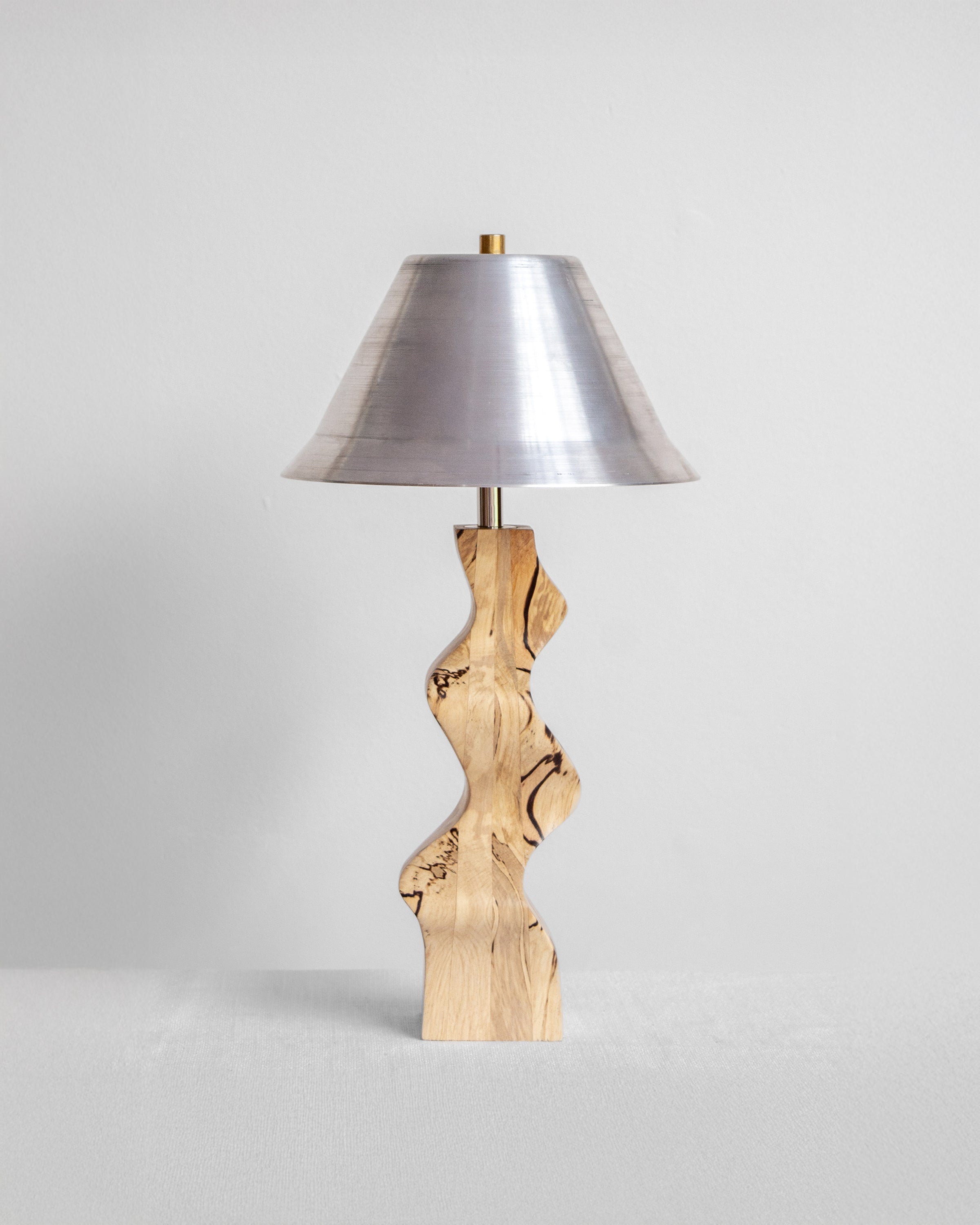 Rippled Desk Lamp with Spalted base and Aluminium shade on a light grey background with UK, EU and US/CA wiring available on white background Wilkinson & Rivera