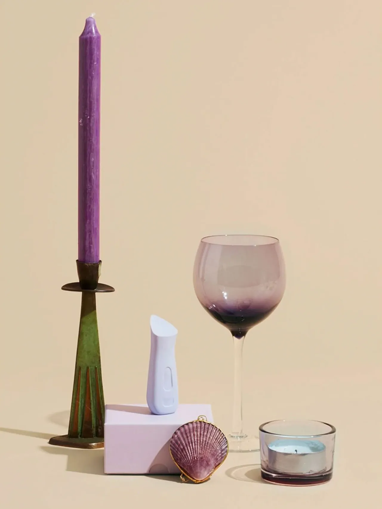 Light gray Kip device displayed with a candle, glassware, and decorative objects