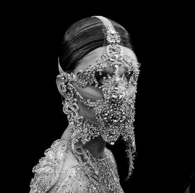 Close-up of a yellow tennis ball sitting on a green court, positioned near the white center line.