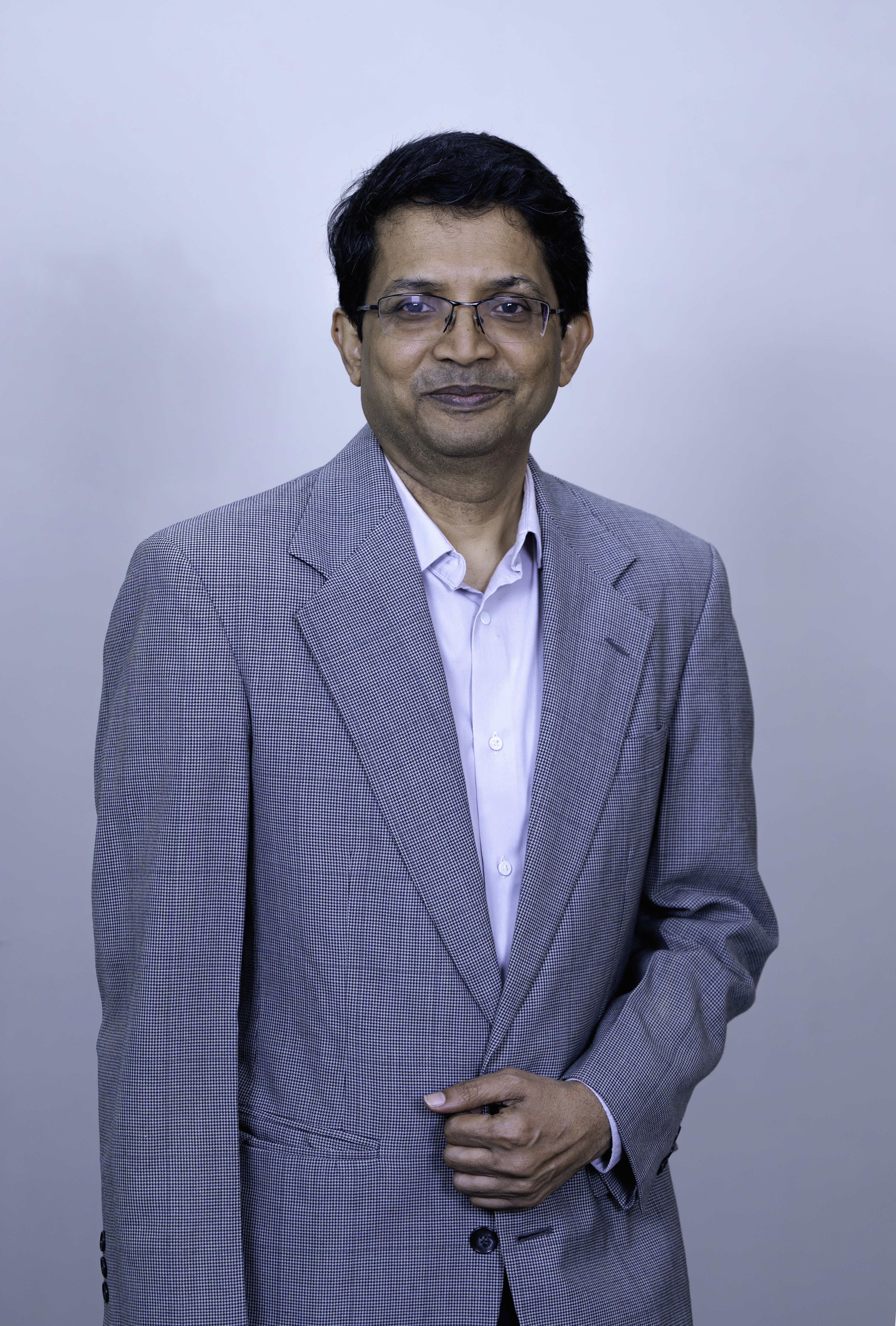 Man with arms crossed in modern office workspace.