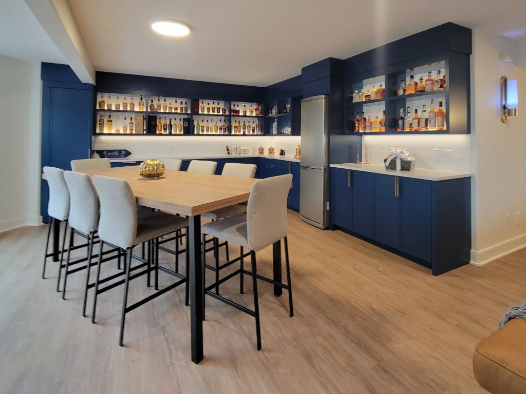 Image of Luxury home bar design with blue cabinetry, white countertops, and furniture by KHD Homes interior design.