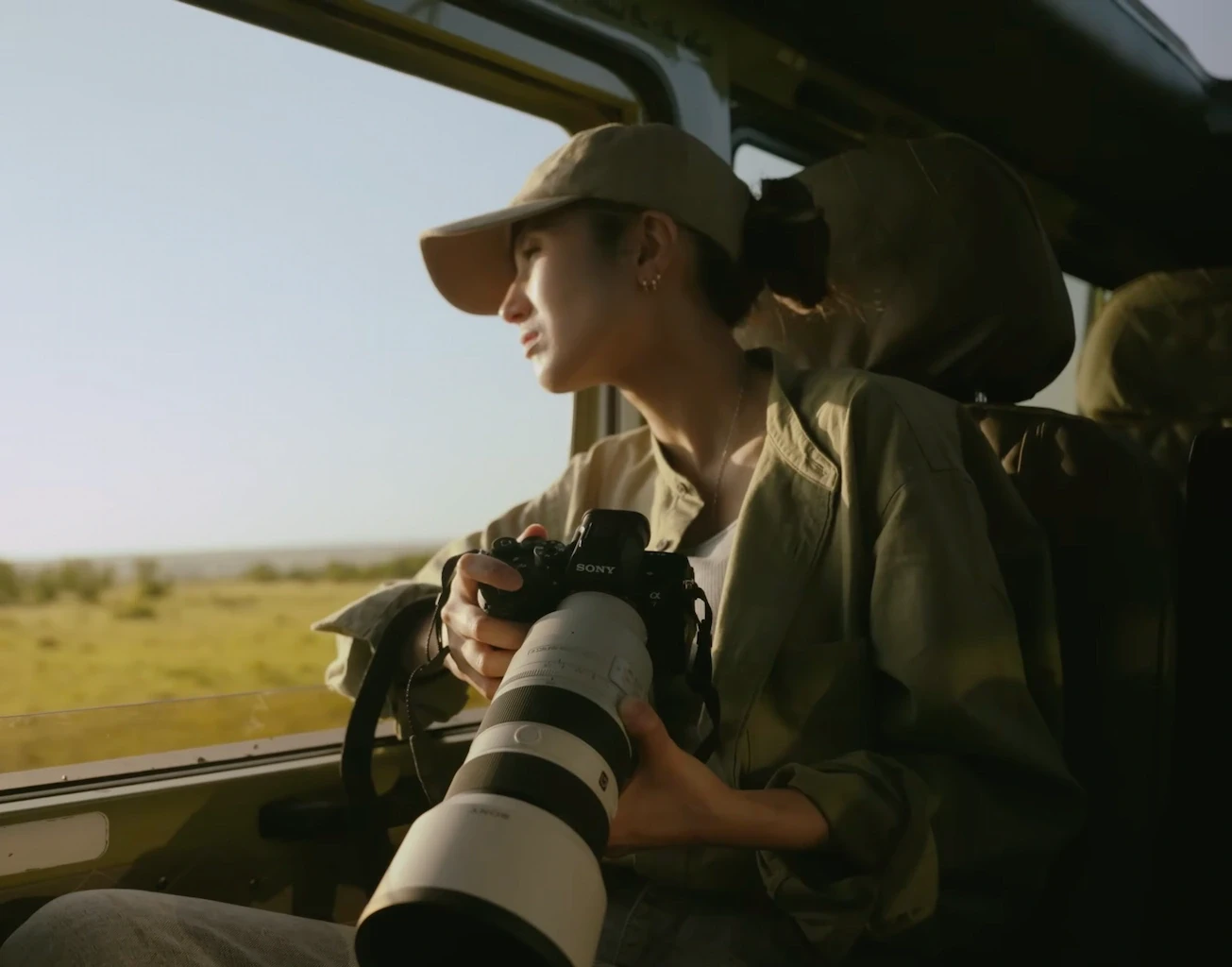 Female wildlife photographer holding camera with large lens