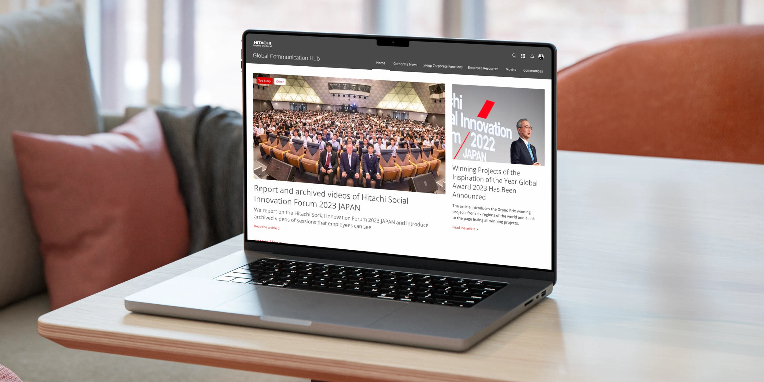 Laptop displaying Hitachi's internal communication platform featuring company news and employee updates on a modern desk