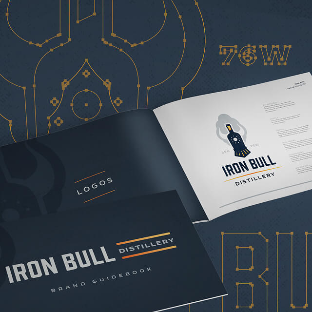 An open brand guidebook displays the Iron Bull Distillery logo, featuring creative branding elements and storytelling design details on the surrounding pages.