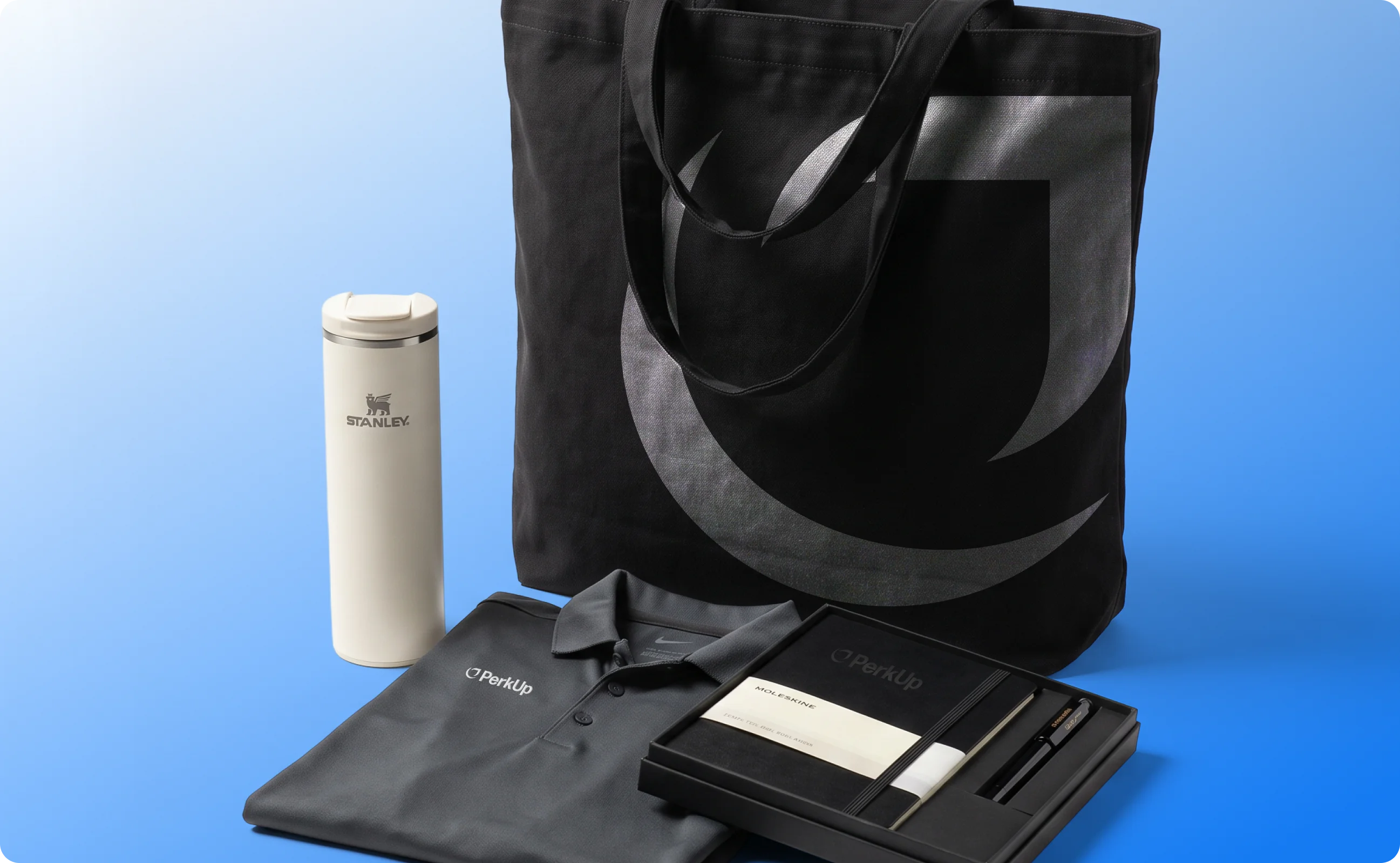 A tote bag, a Stanley tumbler, a polo, and a notebook