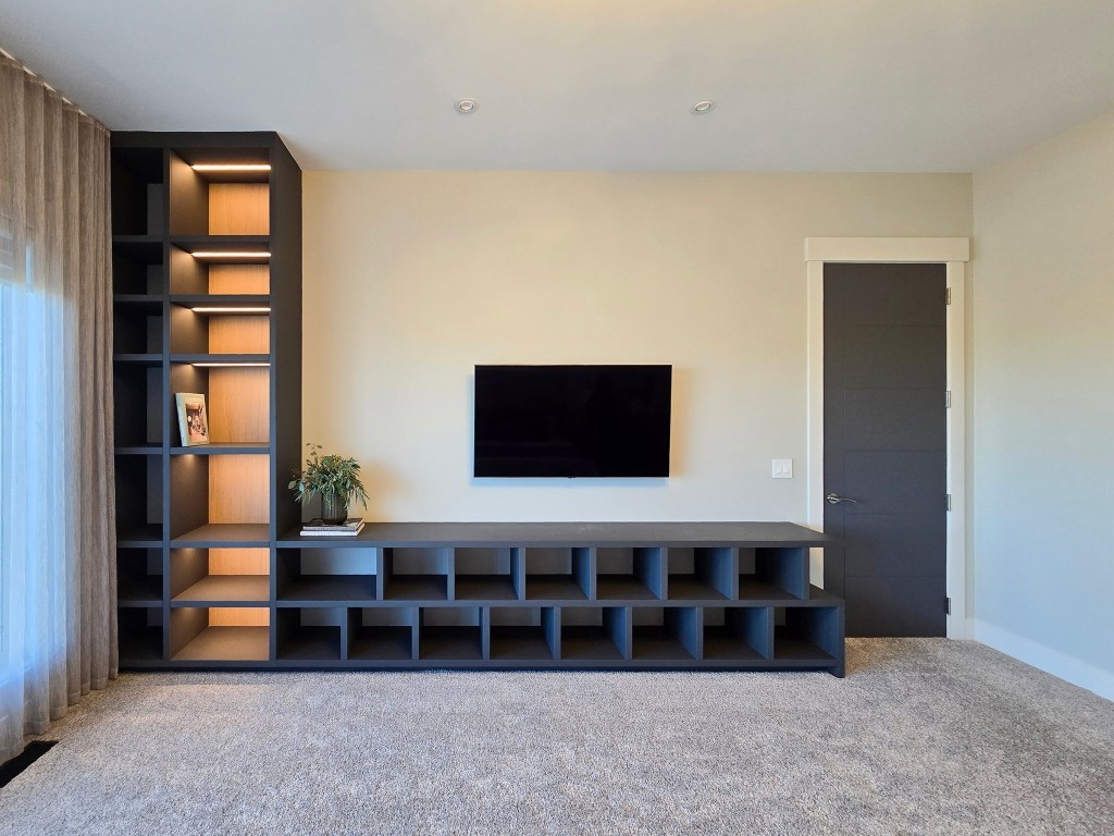 Image of Modern living room design with built-in shelving and media console by KHD Homes interior design experts.