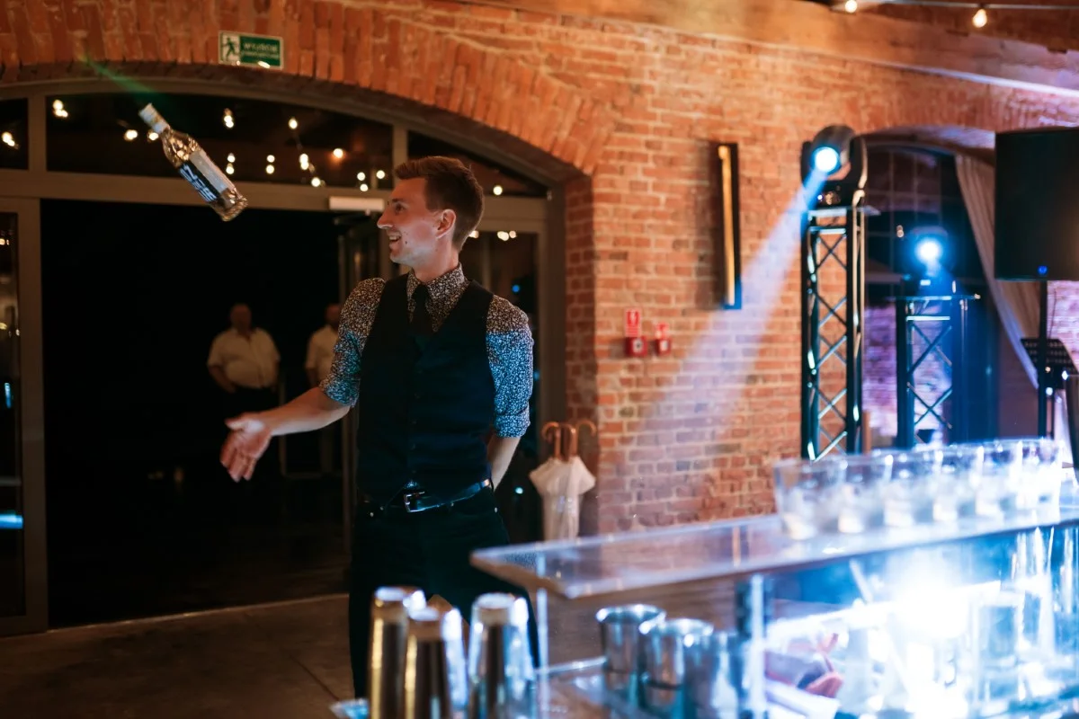 elegancki koktajl przygotowywany przez barmana na wesele przy pomocy sitka