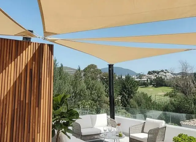 terraza atico con estar y velas de sombra con vistas a la montaña