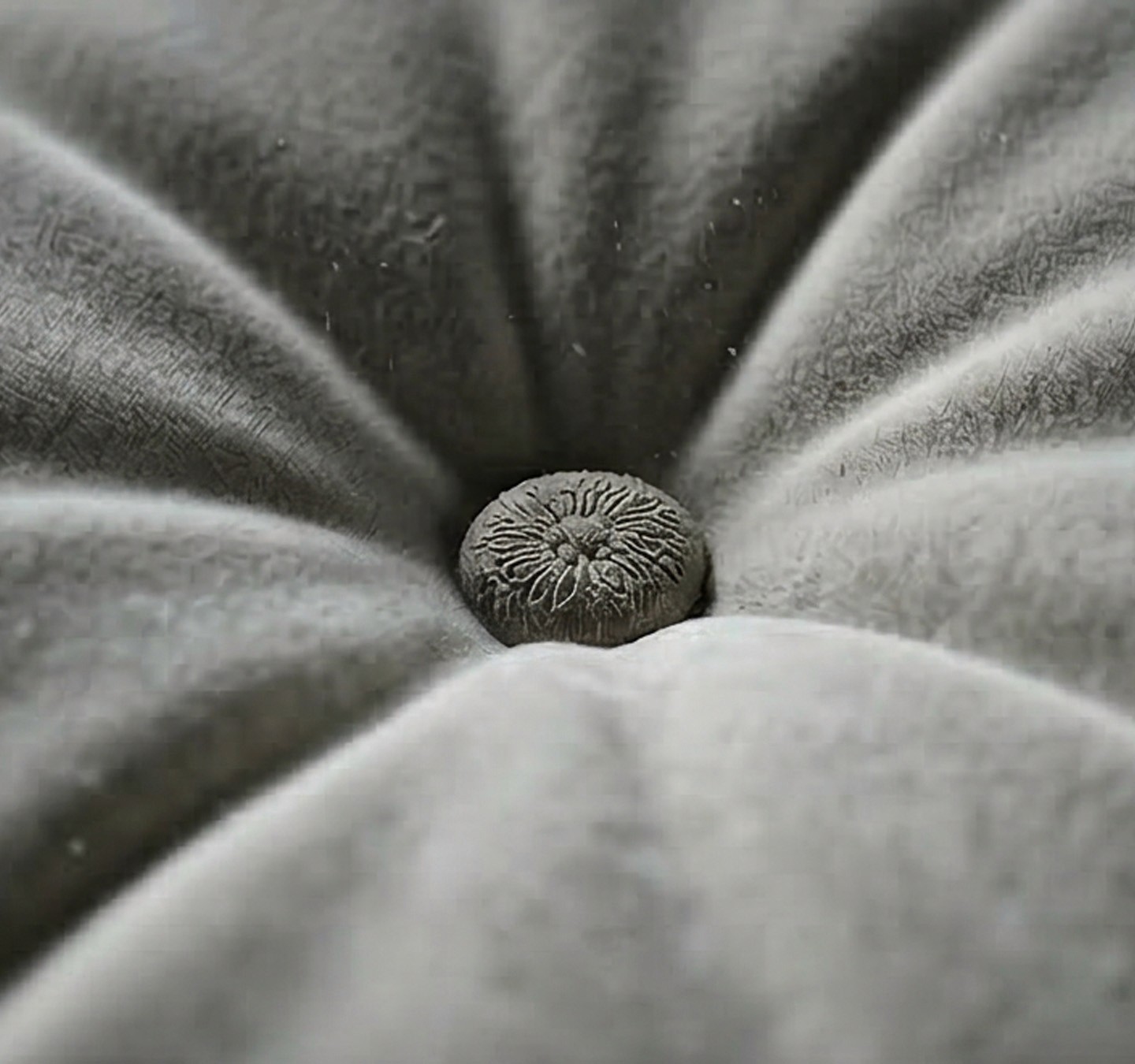 Minimalist entrance with warm beige render, clean steps, and a circular architectural cutout lit by daylight.