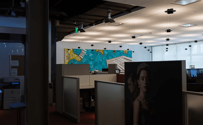 Three models standing in a wheat field, wearing beige suits.