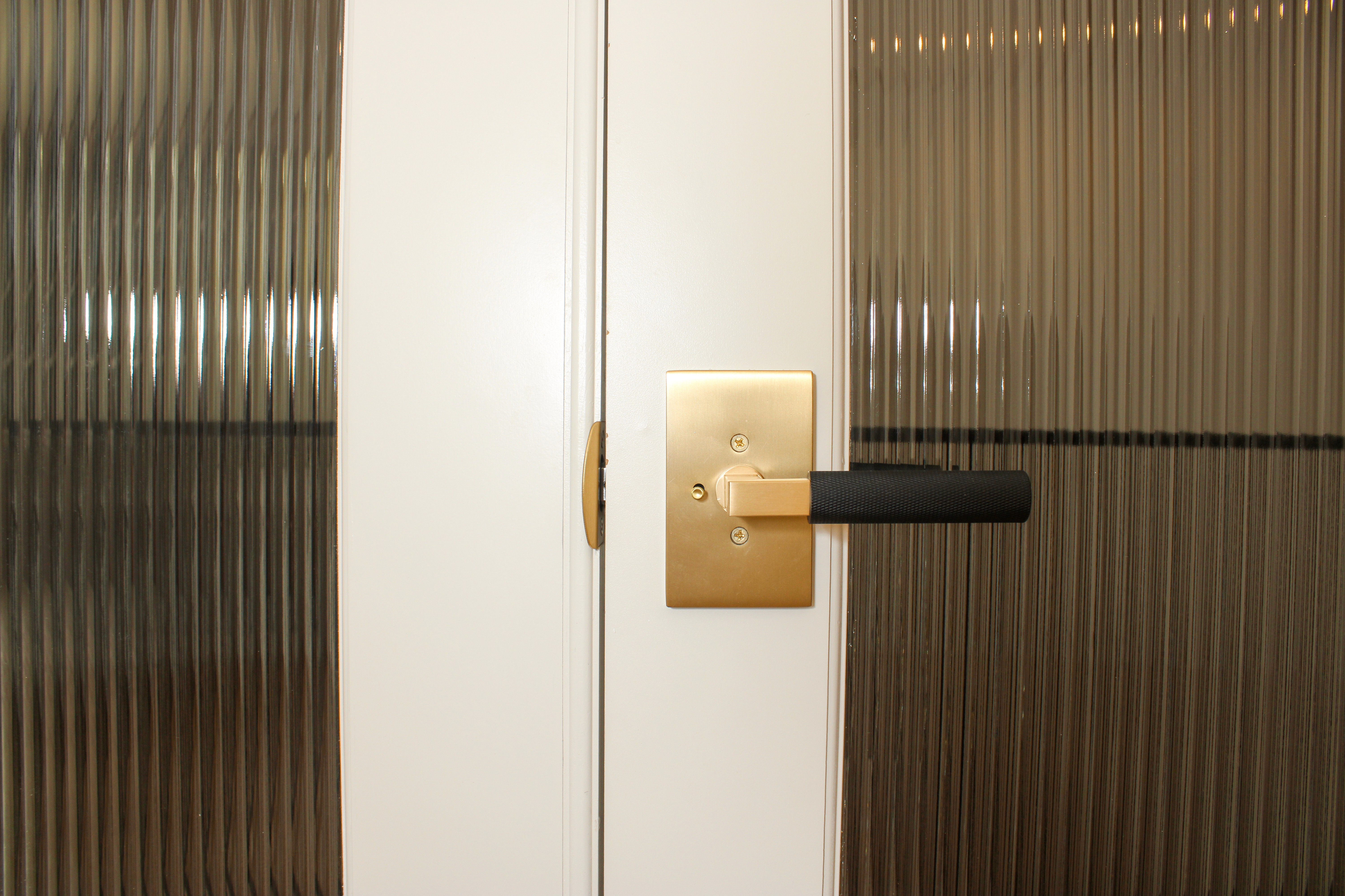 Glass office doors with a two toned door levers in a St. George, Utah home.