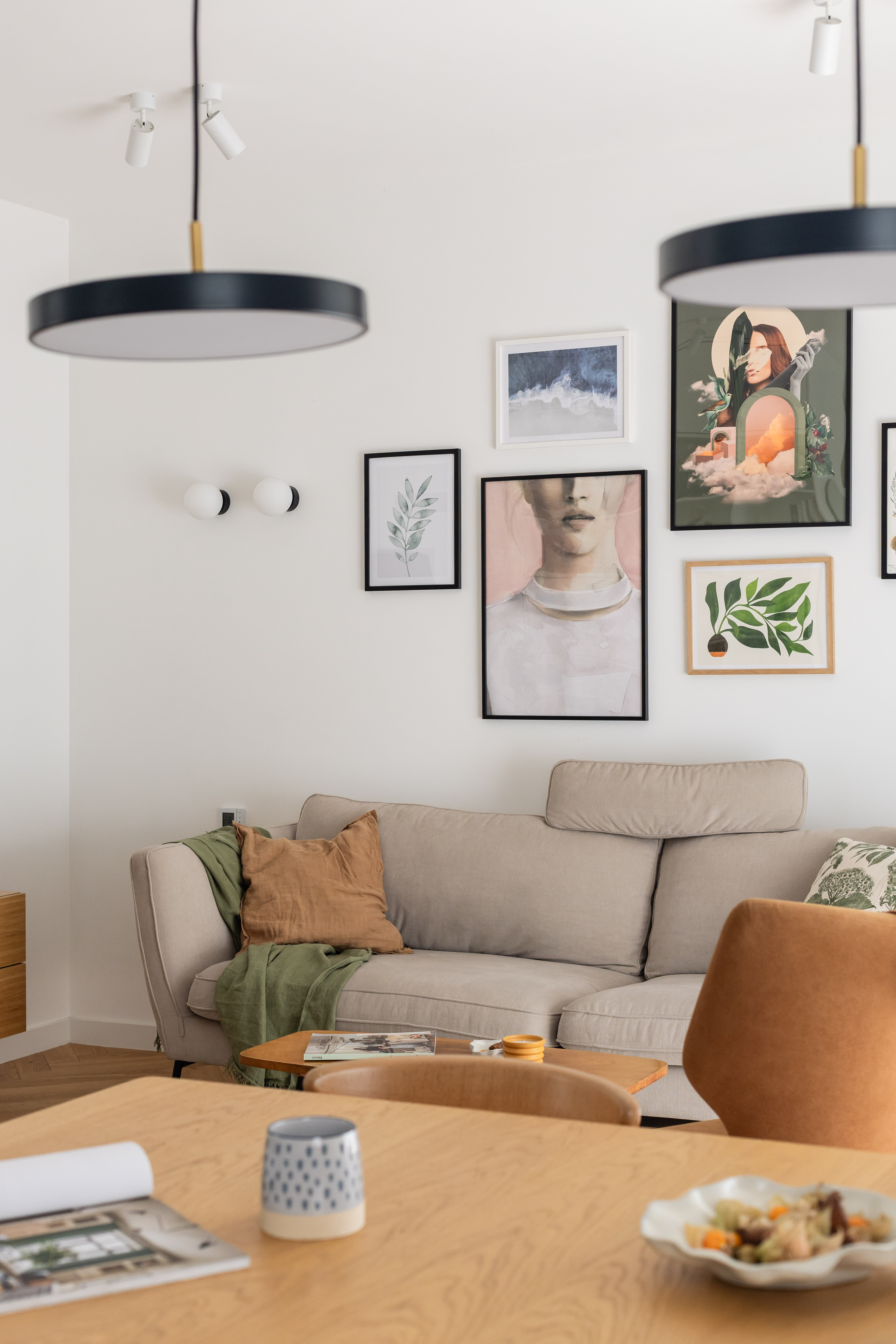 Projekt salonu z beżową sofą i galerią plakatów na ścianie.