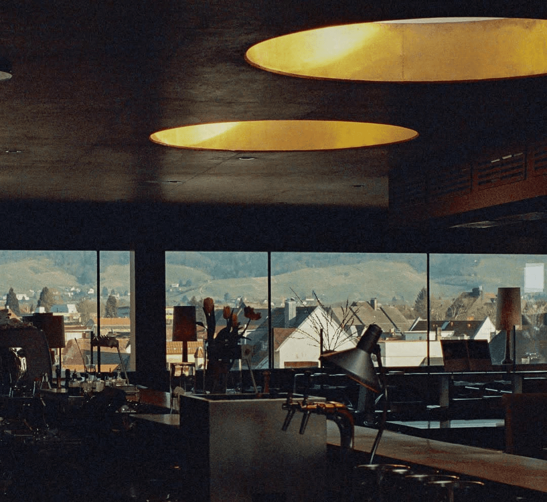 Innenraum des Schöllmanns Restaurants in Offenburg mit großer Fensterfront und Stadtblick