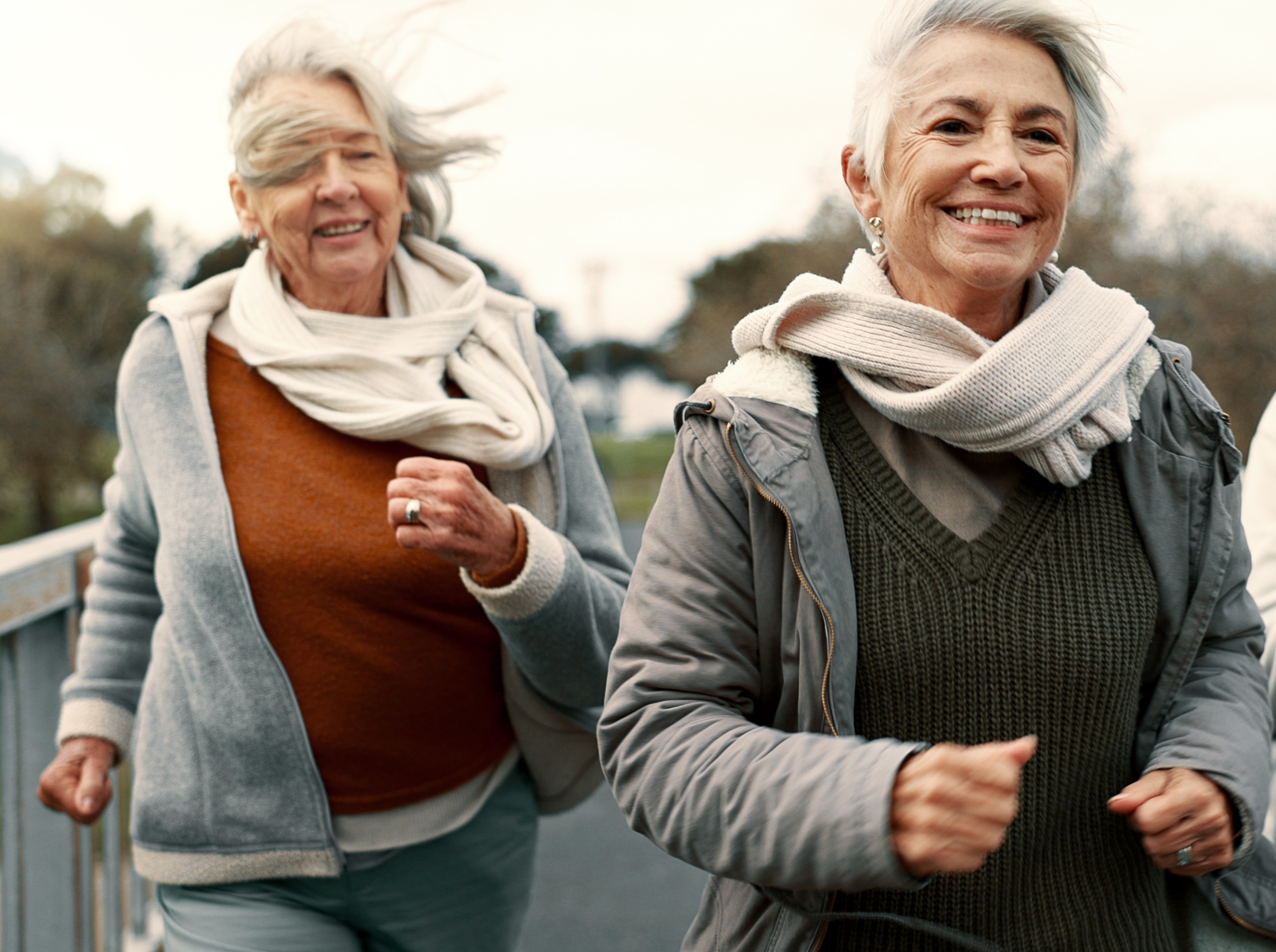 pair of older women in winter workout clothes doing speed weight loss walking