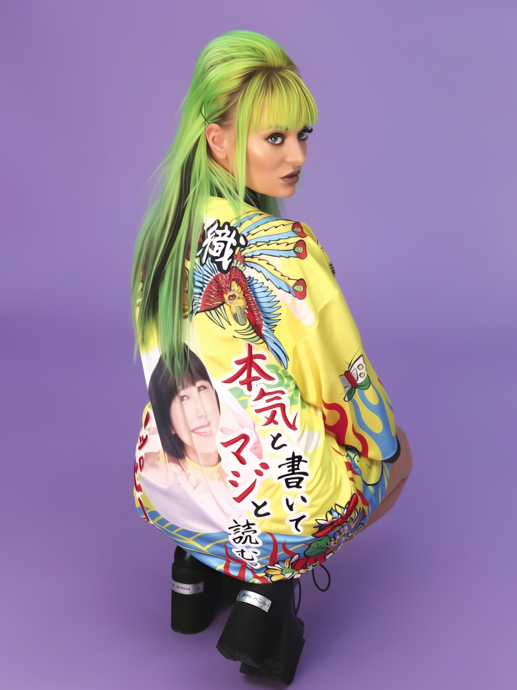 Delia with neon green hair in a yellow jacket with Japanese text and portrait print, purple backdrop.