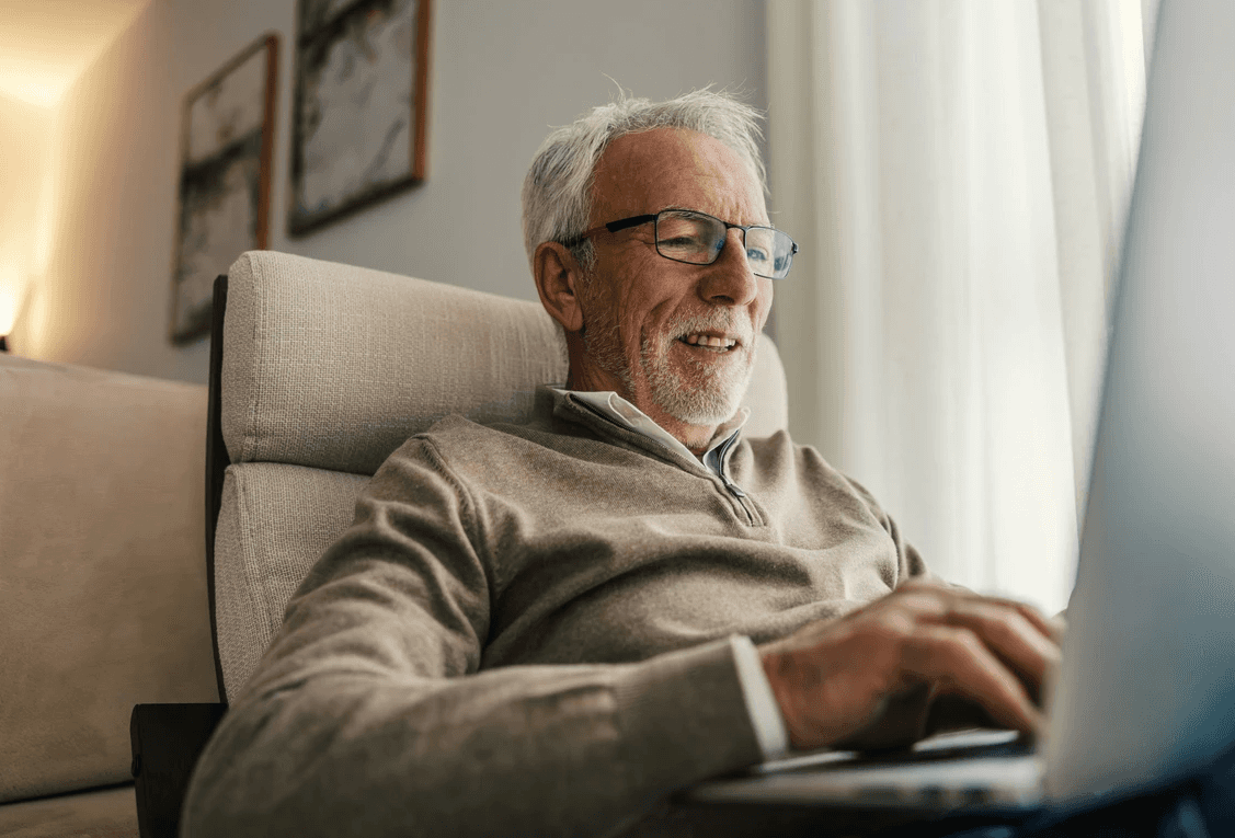 Happy senior man searching healthcare websites