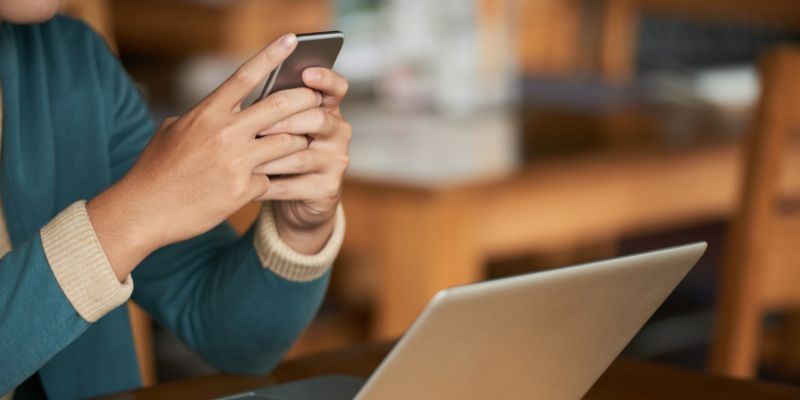 A man using his laptop and phone to check data