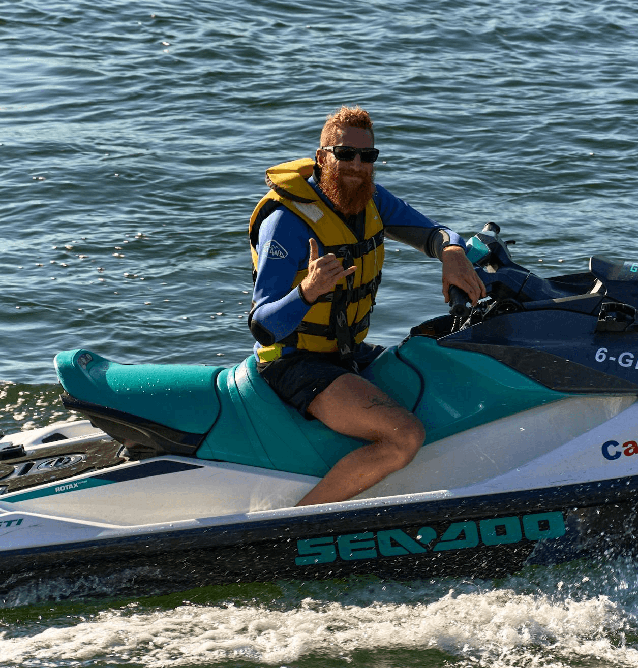 Man posing for a photo while riding a Sea-Doo jet ski.