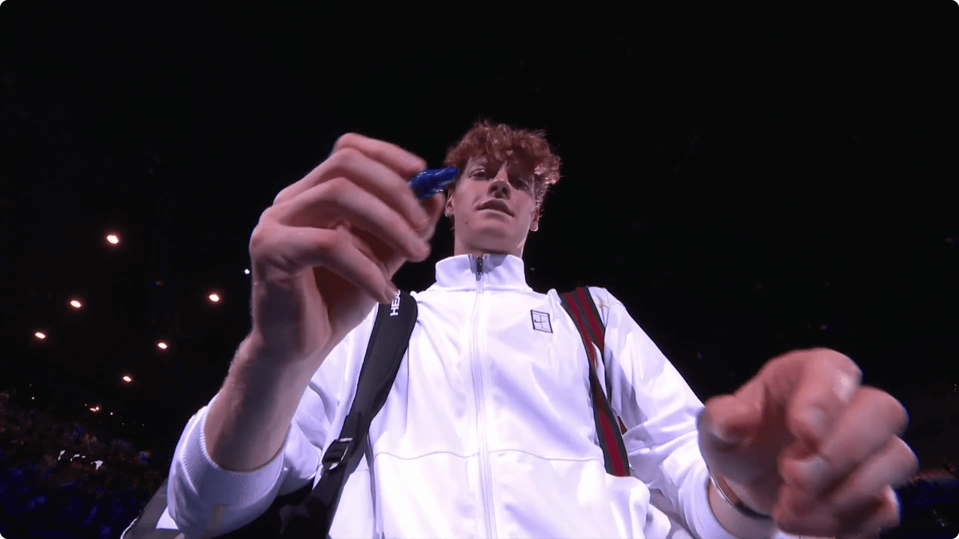 Photo of Janik Sinner signing the camera lens