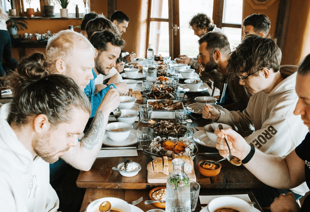 Groep mannen die op de laatste dag weer samen aan tafel zit voor een heerlijke maaltijd
