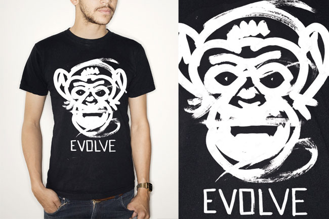 A man wears a black t-shirt with a white stylized monkey face design and the word "EVOLVE" printed below it. The design is in a brushstroke style. The man is also wearing blue jeans and a watch on his left wrist. The image includes a close-up of the monkey face design and the word "EVOLVE" on a black background.