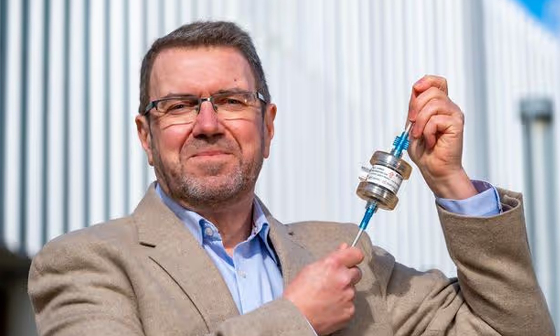 A photo of a man holding a liquid biopsy device