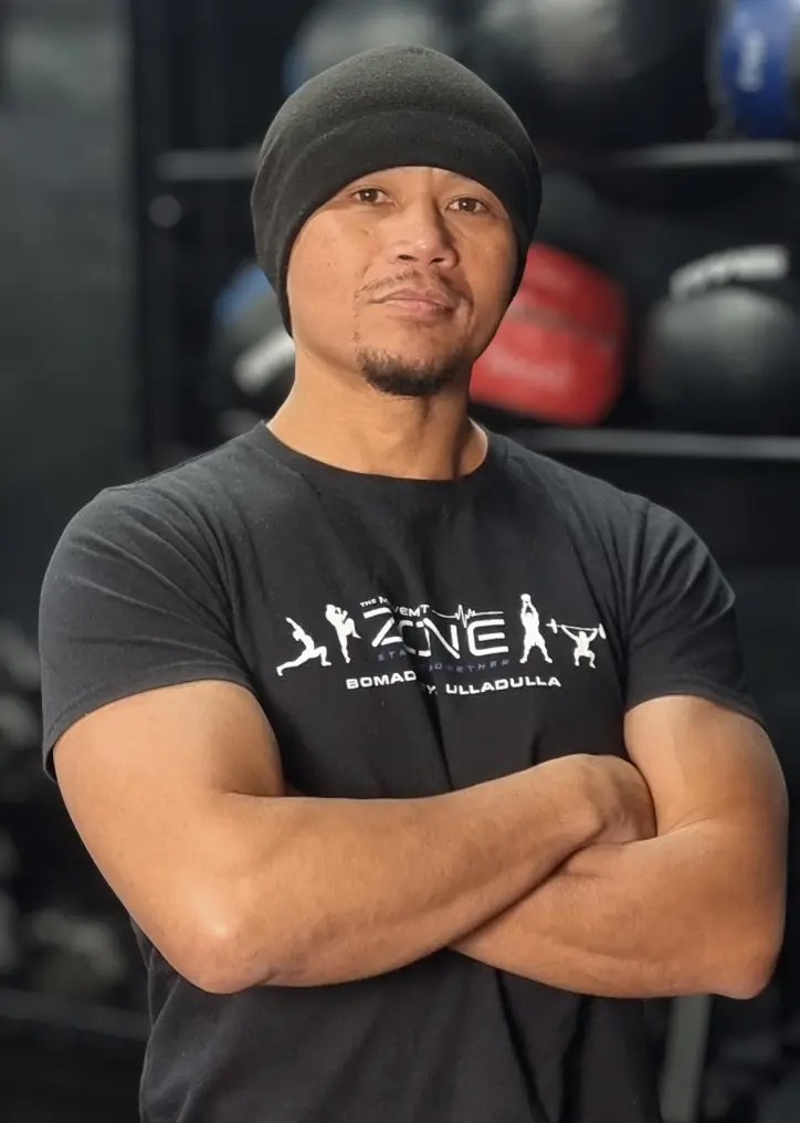 Coach Ian Harding with a calm expression and arms crossed, ready to train.