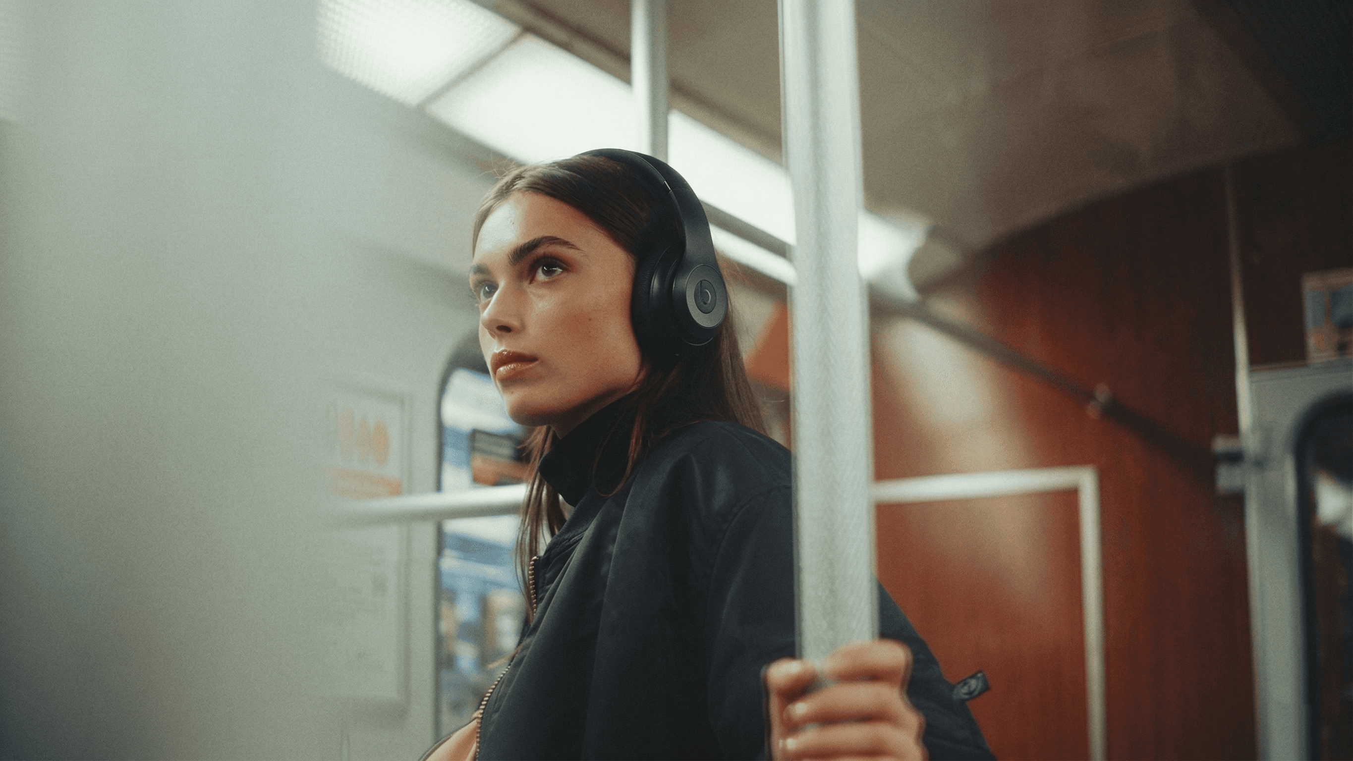 A fast black sports car races down the highway.