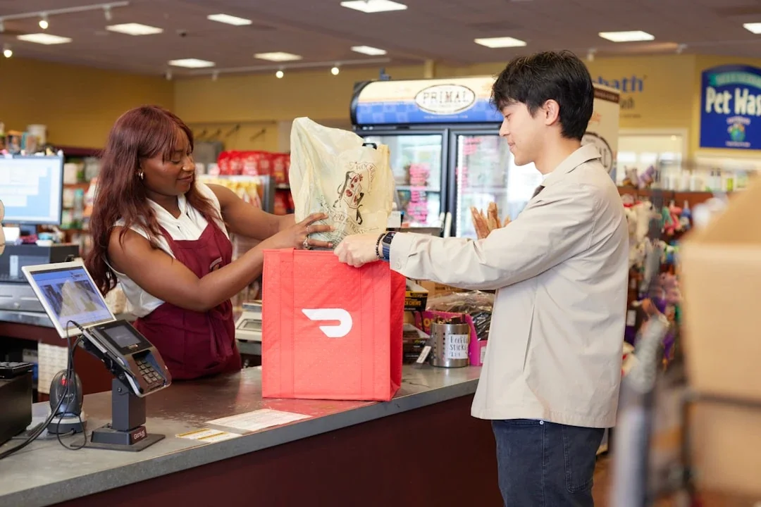 woman bagging pet supplies in DoorDash bag for customer
