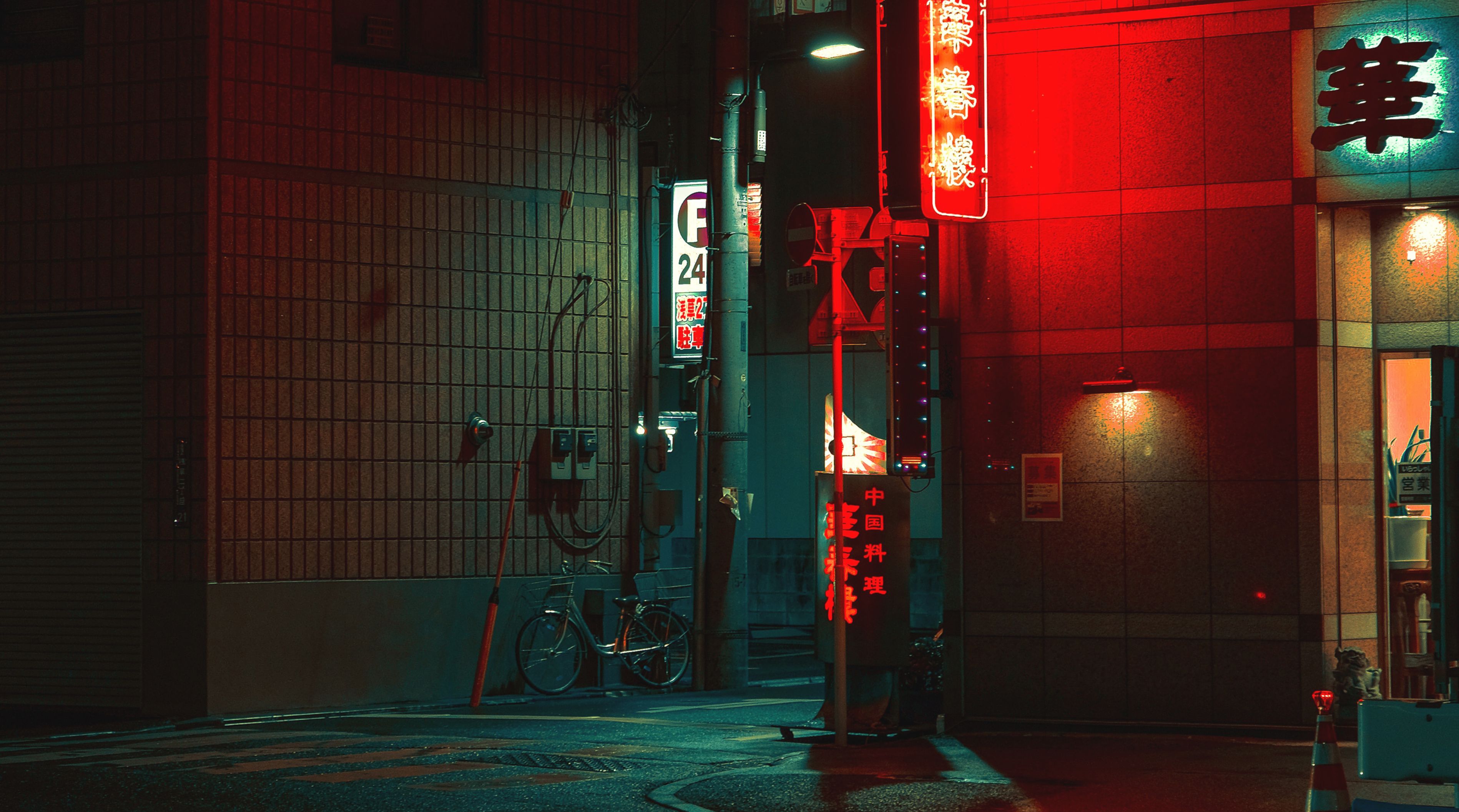 A street scene in Tokyo at night. Neon red dominates the right frame.