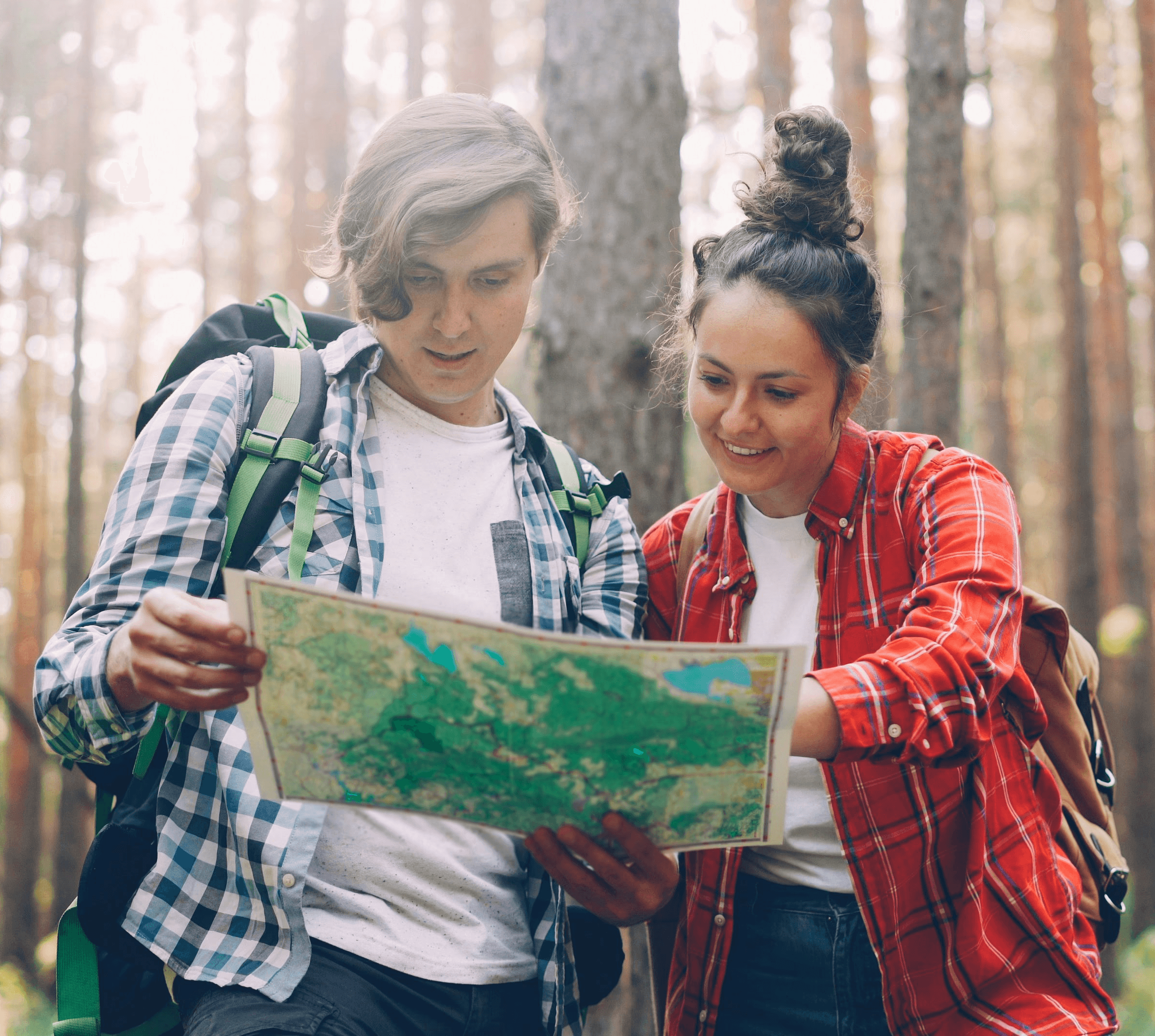Two hikers looking at a map in a forest