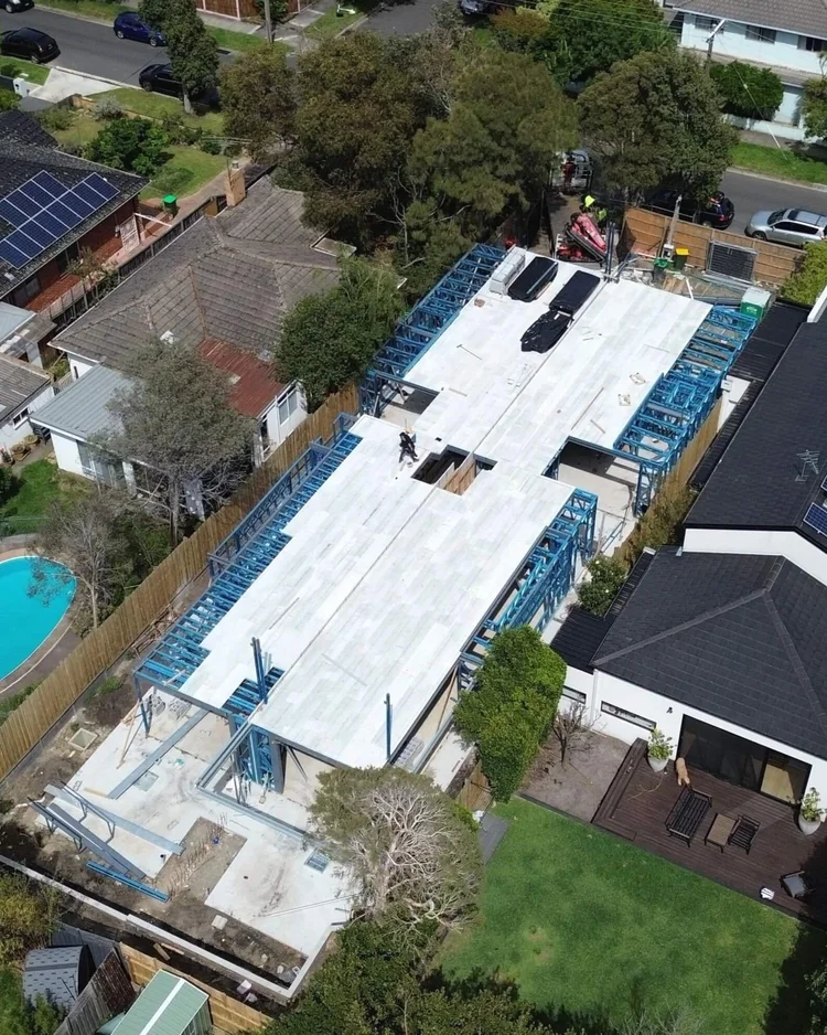 Aerial view of modern residential construction site with steel framework in urban area.