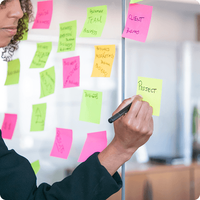 woman using post-it-note kanban board