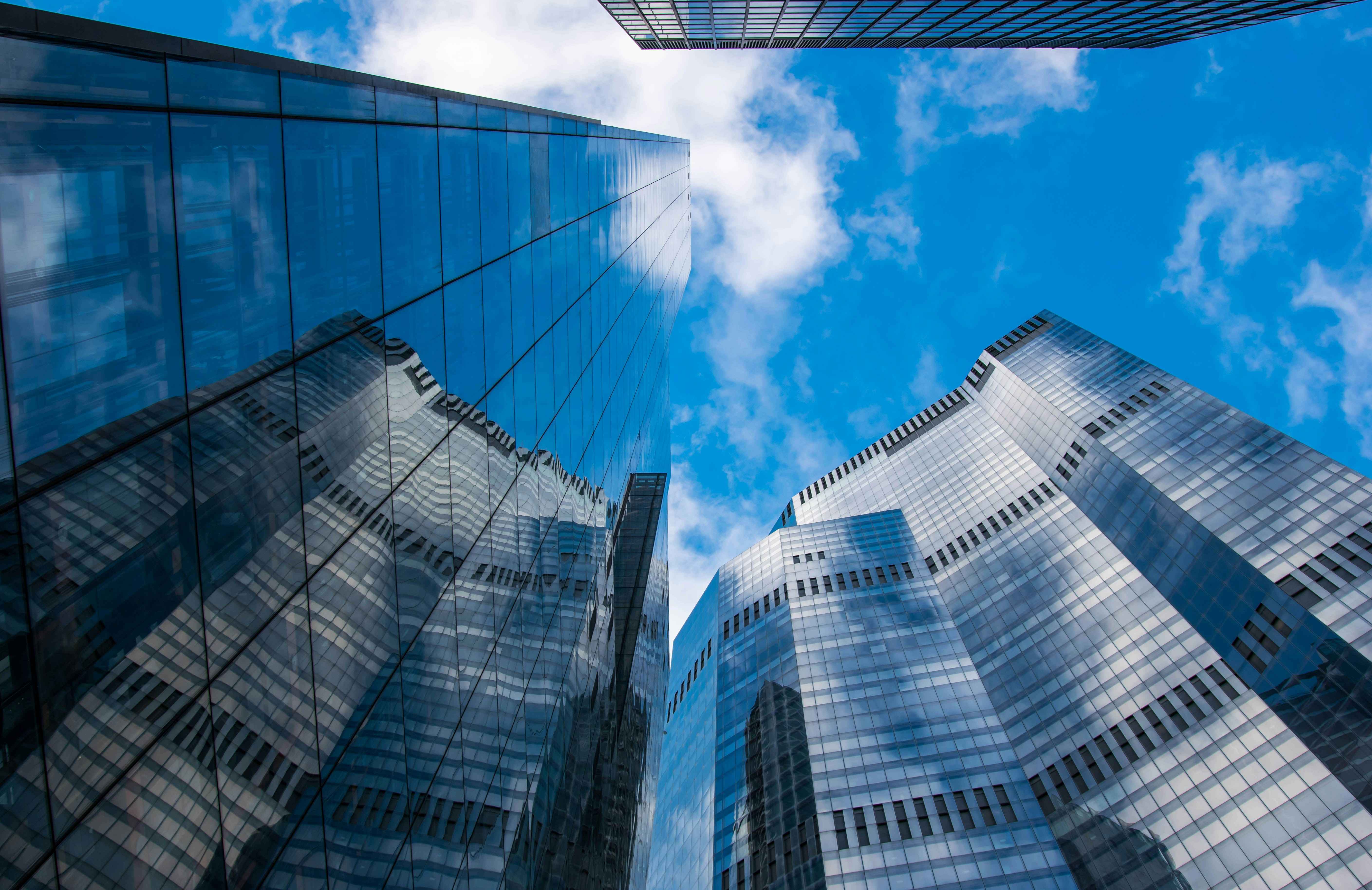 Modern glass office buildings viewed from below against a clear blue sky, representing the corporate and commercial landscape in Turkey