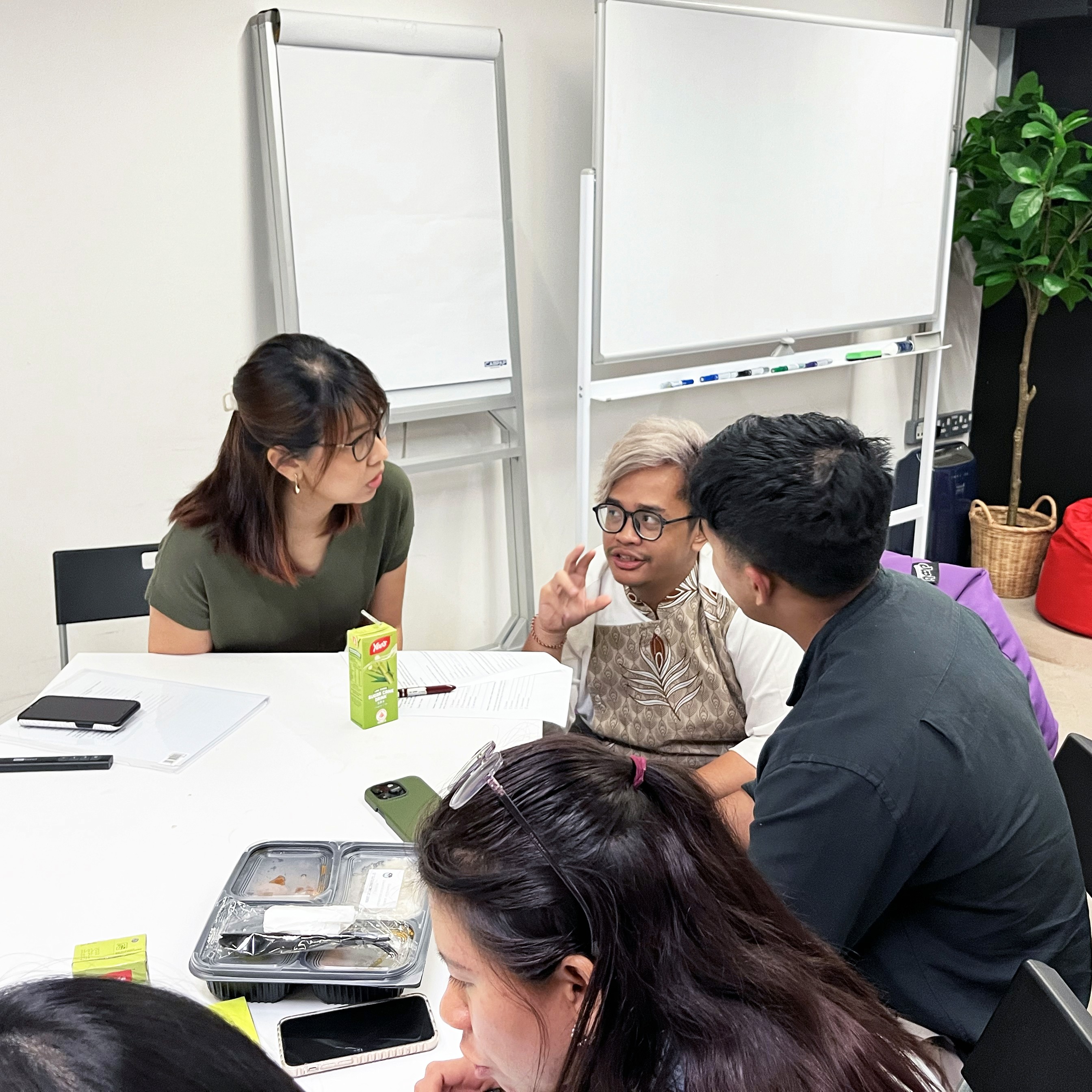 Two workshop participant asking the facilitator questions during the Designing a Problem Statement session