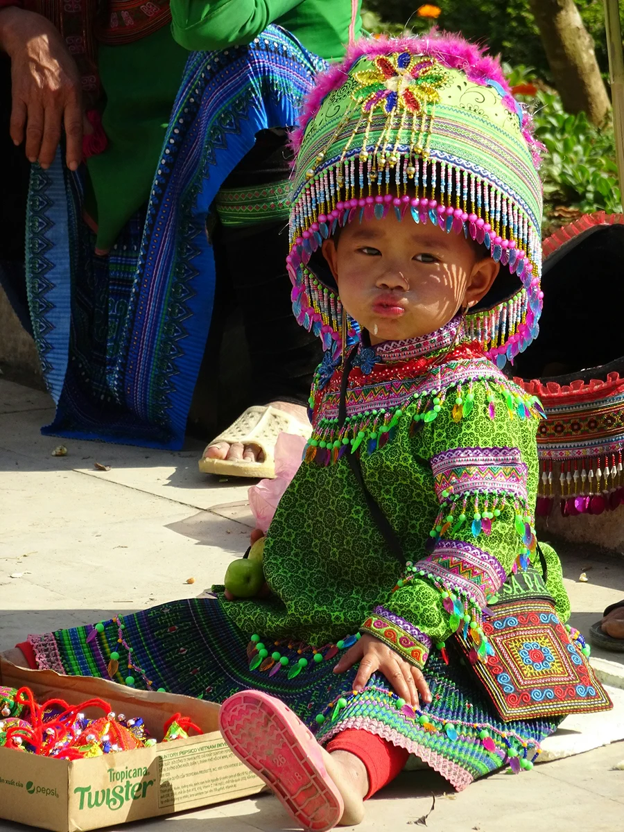 Child wearing colorful embroidered clothing and a knitted hat