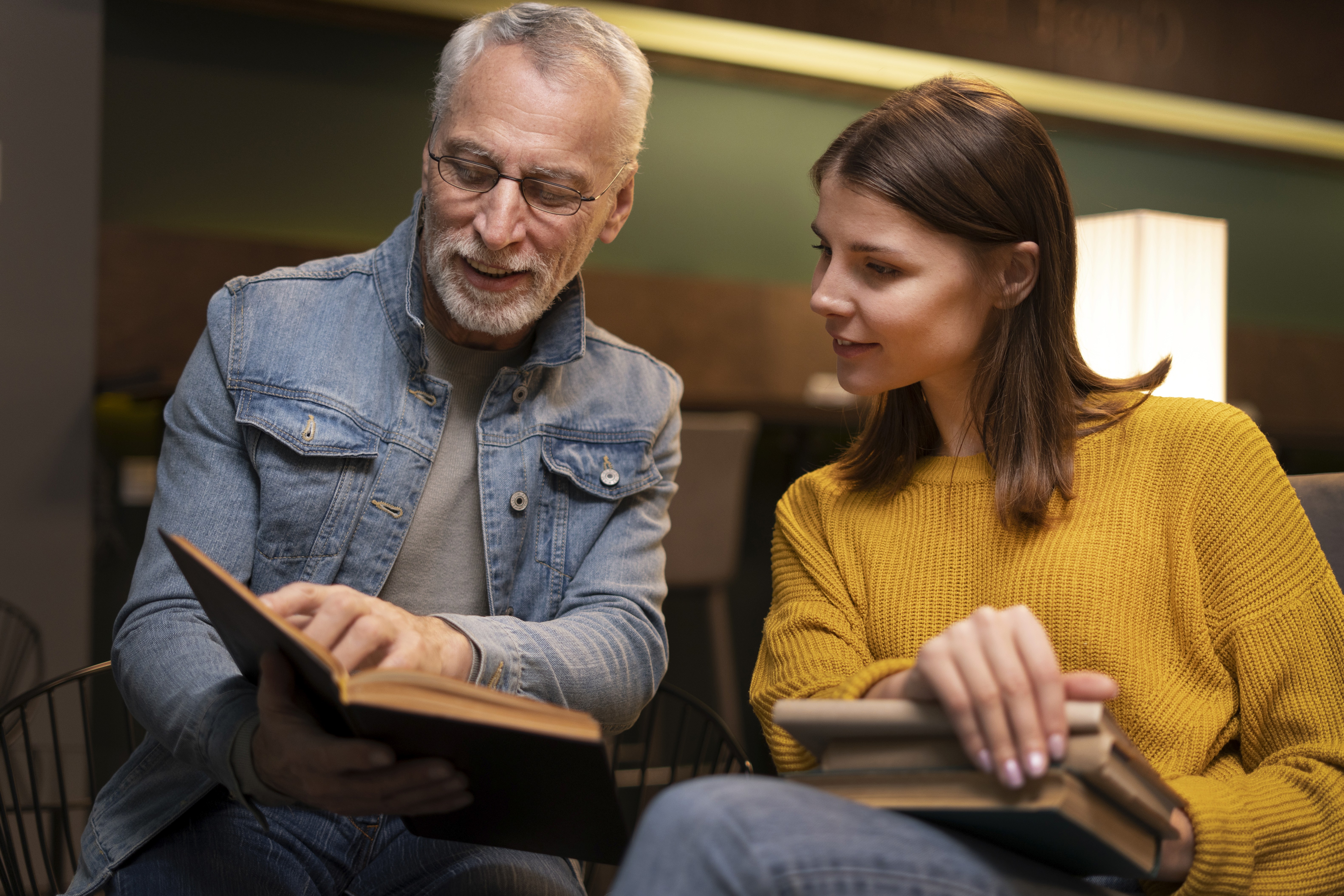 Conversion Truth for Families - Teen girl in mustard sweater holding a book, looking toward her father, holding another open book