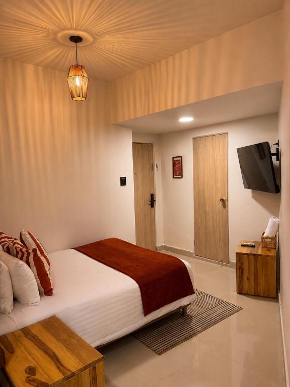 Downtown Express: Bedroom with red bedding accents and a woven pendant light