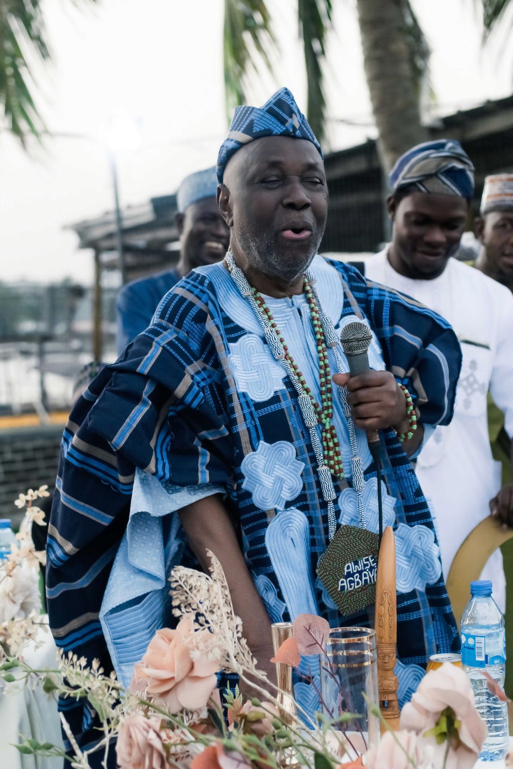 Luxury wedding planned by Victoria Brooks Events in Nigeria with elegant décor and beautiful reception. Groom in a blue suit and bride in a white wedding dress with flowers surrounded by family and friends.