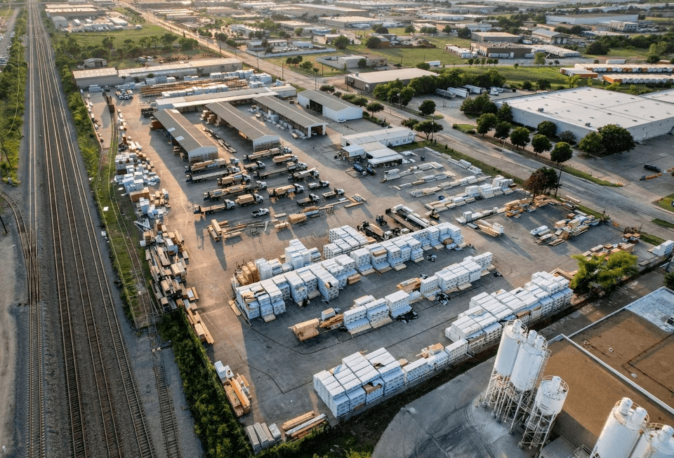 Aerial view of an industrial outdoor storage yard running alongside a rail line