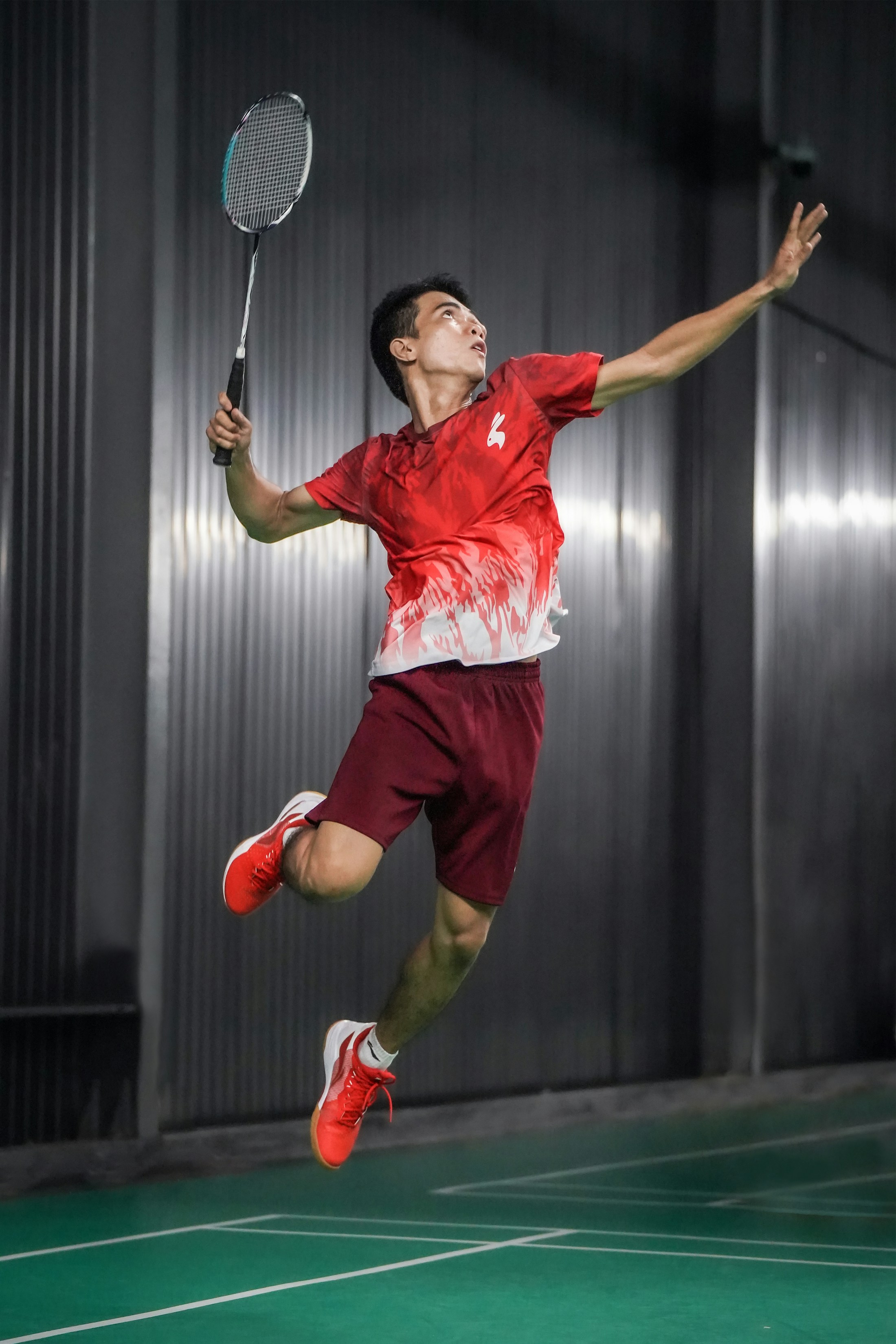 Badminton player jumping on an indoor court