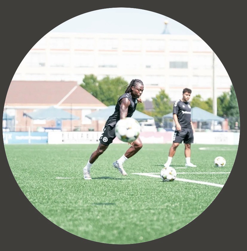 Elderly person gazes confidently to the side, wearing large, dangling earrings and a dark sweater, against a soft, neutral background. Serene and elegant tone.