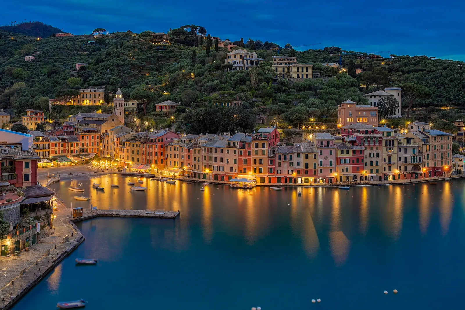 Evening harbour with hillside villas and calm water representing structured private wealth, family trusts and long-term financial planning