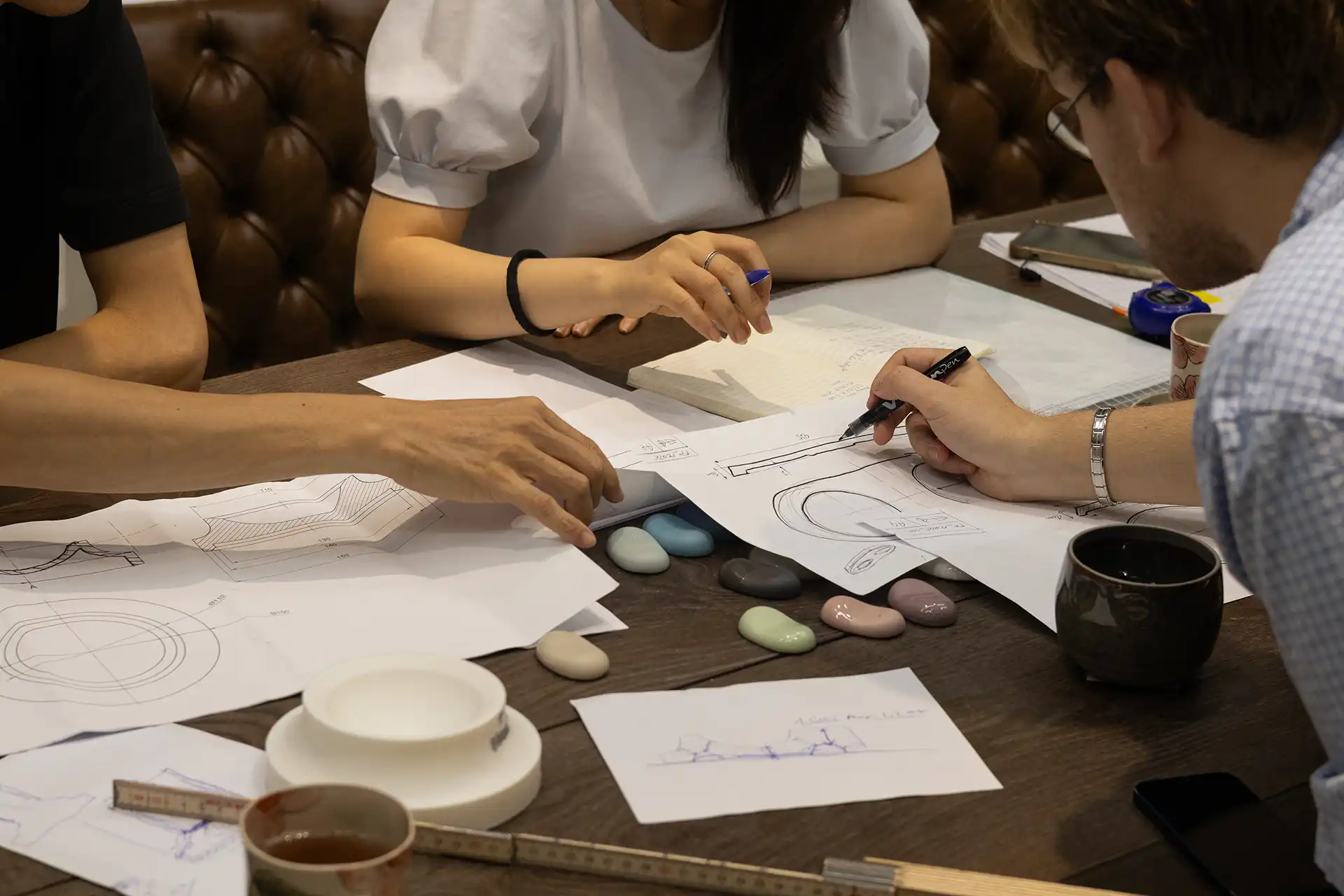 Yannik discussing designs with two producers on a table