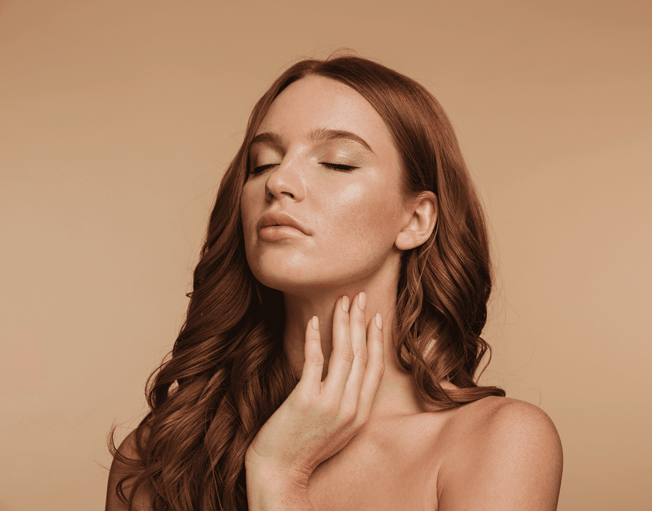 A person in an orange jacket and sunglasses, with braided hair, against orange.