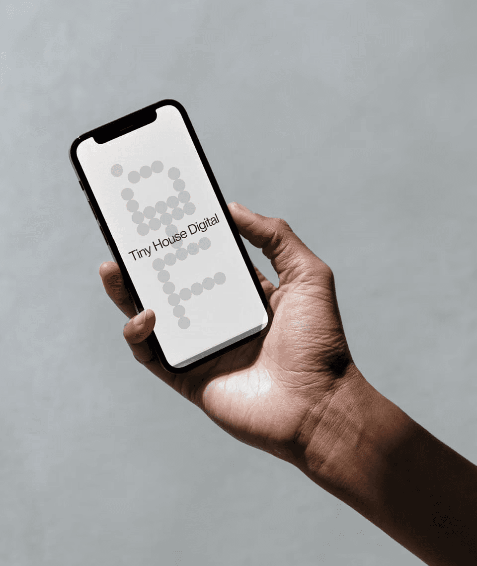 A person holding a phone in which it's shown a visual design for tiny house digital.