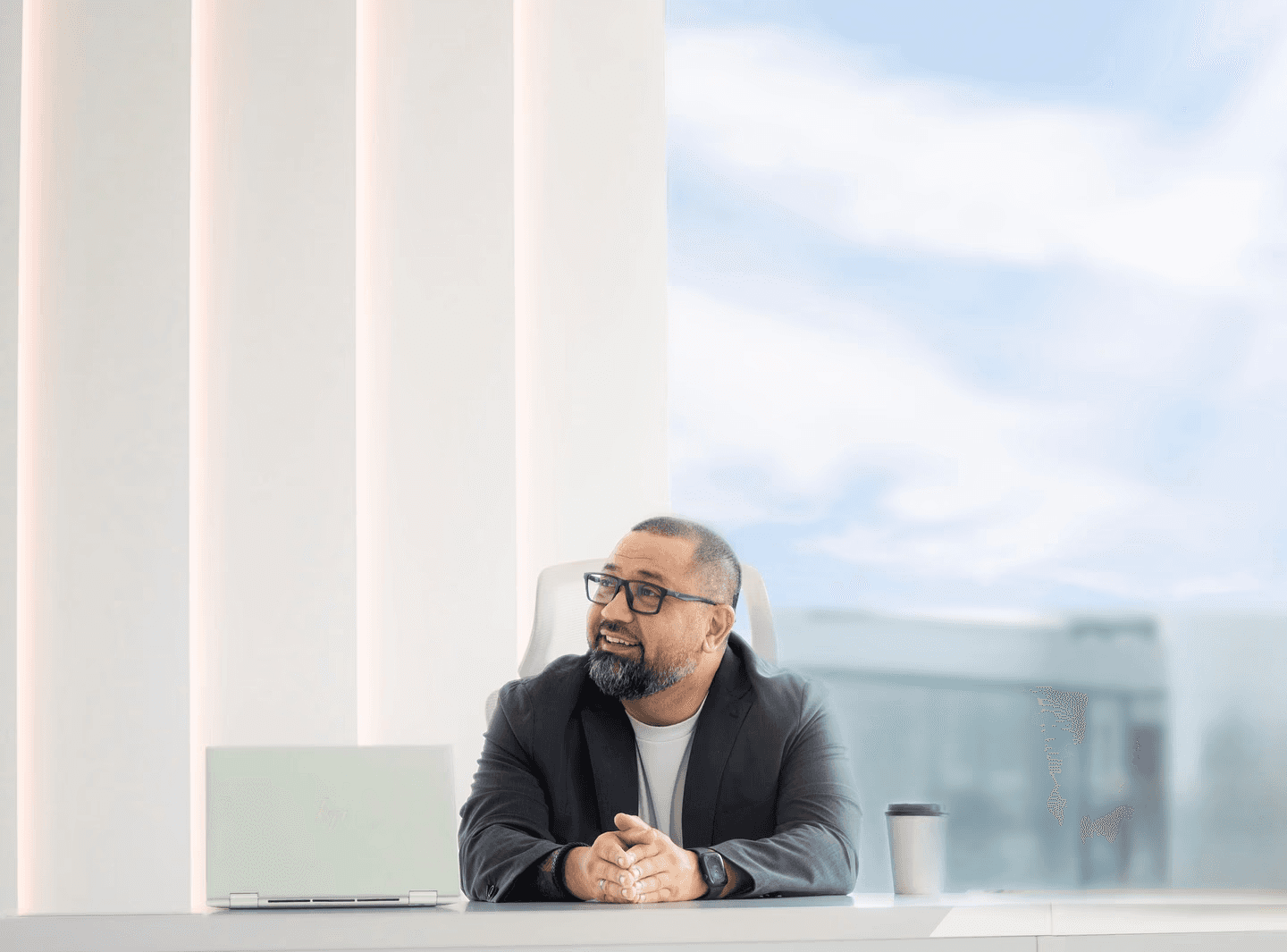 Black-and-white party photo of a smiling man in a check blazer among a crowd.