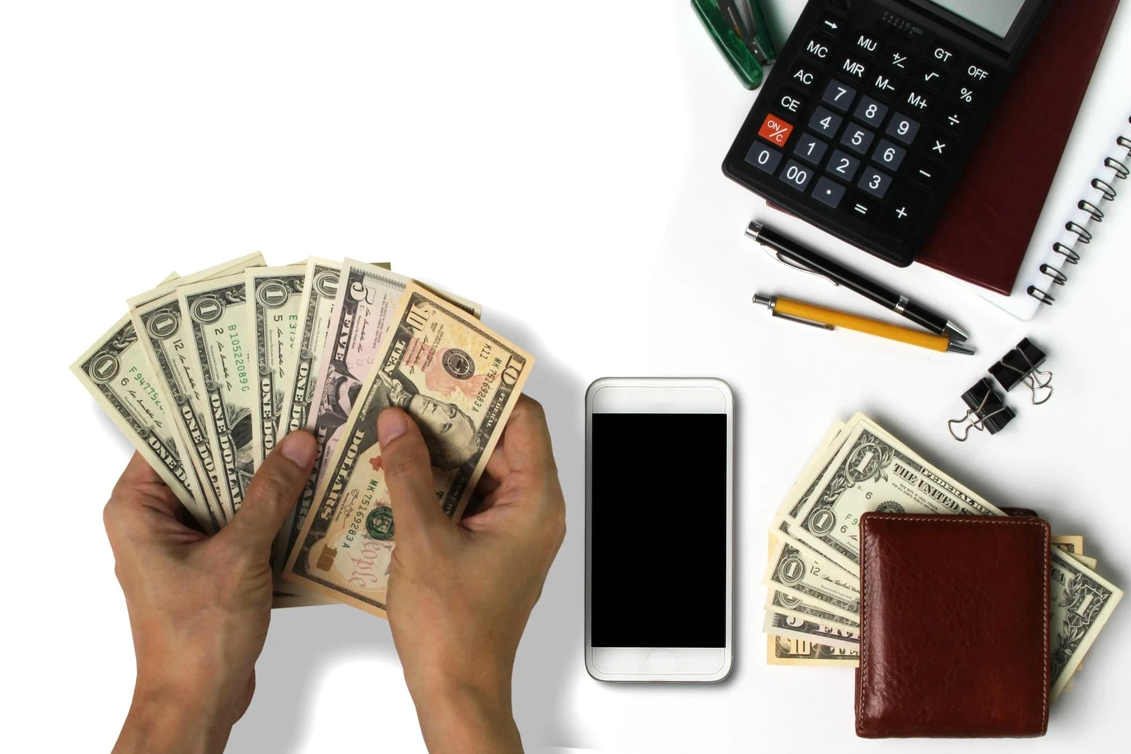 High angle view of hands holding paper currency on desk