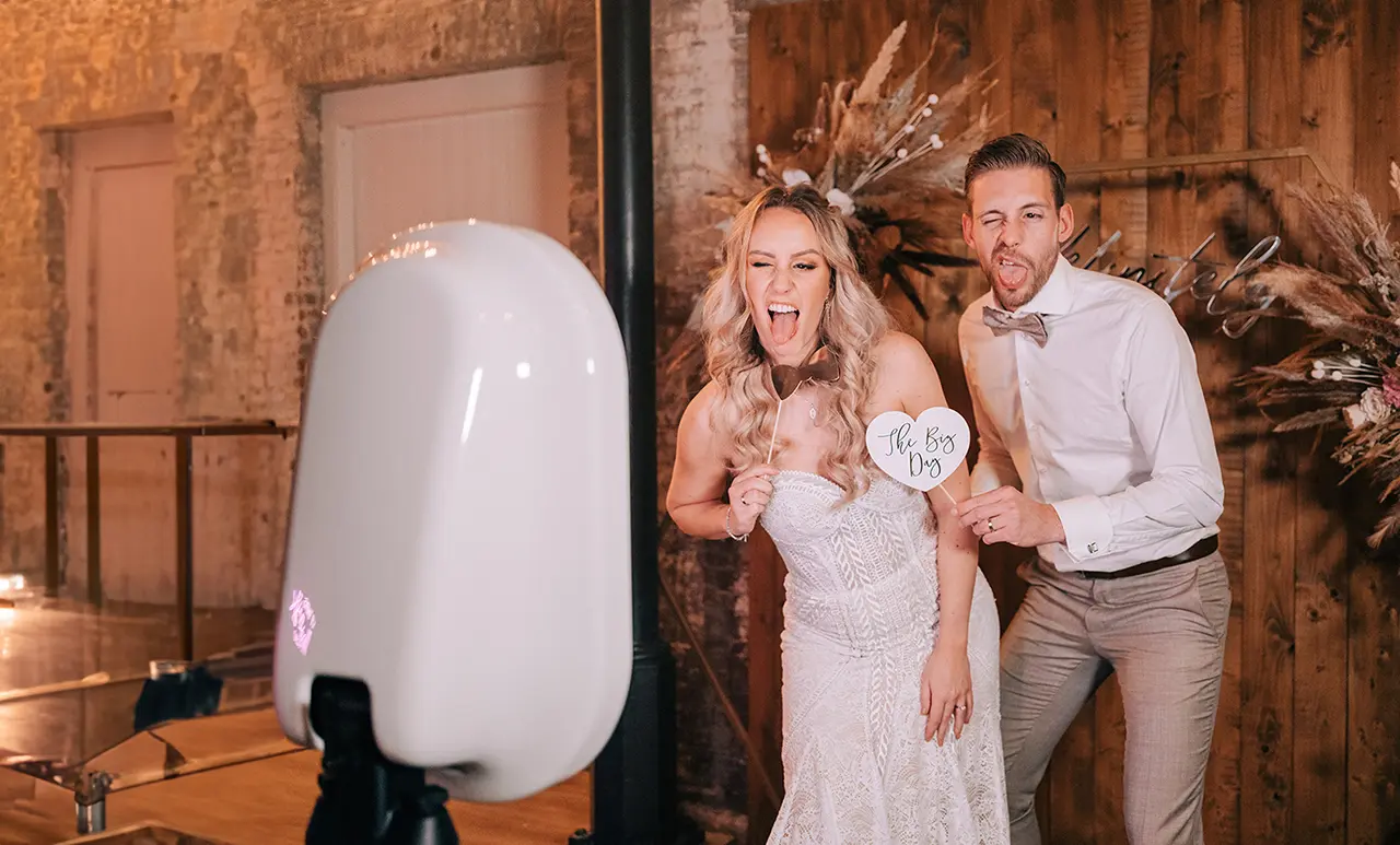 Bruidspaar poserend voor de photobooth van 321Klik met fotoprops in de handen